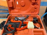 une boîte à outils orange contenant des outils, posée sur une table
