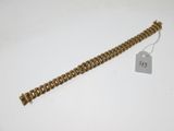 gros plan d'un bracelet en chaîne en or avec une étiquette de prix