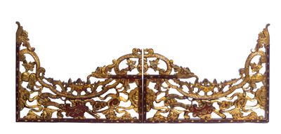 une grande tête de lit en or richement décorée, sur laquelle figure une croix