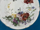 a white plate with flowers and a bee on it