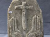 an image of a stone sculpture of a person holding a cross