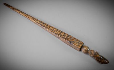 an old wooden stick with writing on it sitting on a table