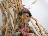 une statue représentant une femme assise sur une branche d'arbre