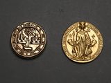 a close up of two gold coins on a black surface