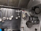 pots and pans hanging from the ceiling in a kitchen