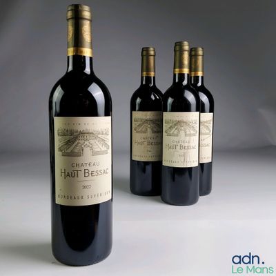 three bottles of red wine sitting next to each other on a table