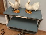 two white birds sitting on top of a blue table