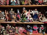 une étagère remplie de poupées et de figurines dans une pièce