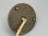 un petit objet métallique d'où sort un bâtonnet en bois