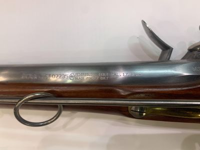 un fusil avec un canon en bois et une poignée en métal