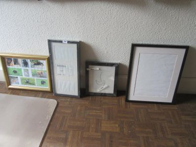 trois photos encadrées posées par terre près d'un mur