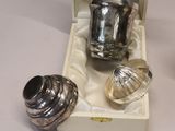 a silver tea pot and a silver cup in a box