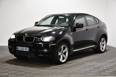 une photo d'un SUV BMW noir garé sur un sol à damier