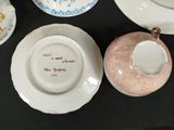 three plates and a bowl on a table with a cup and saucer on it