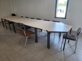 des tables et des chaises dans une pièce dotée d'une grande fenêtre et d'un sol carrelé