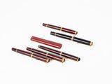 quatre stylos sont alignés sur une surface blanche