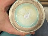 a person holding a cup with a tag on it