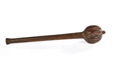 une vieille cuillère en bois avec un manche en bois posée sur une surface blanche