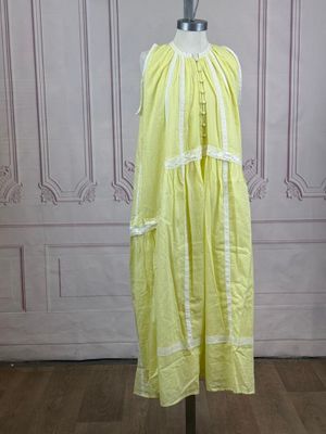 a yellow dress on a mannequin stand in a room