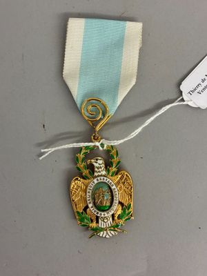une image représentant une médaille entourée d'un ruban et à laquelle est attachée une étiquette