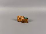 une image d'une bague en or avec une pierre verte au centre