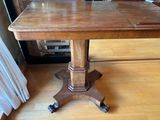 a wooden table with wheels on it in a living room
