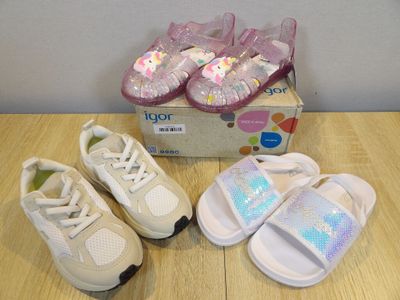 three pairs of baby shoes on a table next to a box of shoes