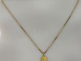 un collier plaqué or avec un pendentif représentant le visage de Jésus, monté sur une chaîne en or