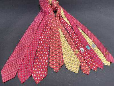 several ties of different colors are tied together on a black surface