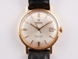 a gold wrist watch with a white dial on a black strap
