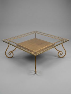 a brass and glass coffee table with a square glass top
