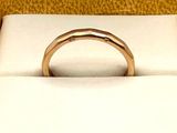 a gold ring sitting in a box on a white surface