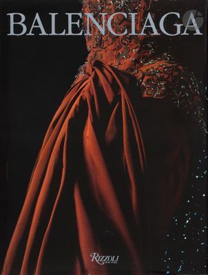 un livre sur lequel figure une robe rouge, posé sur une table