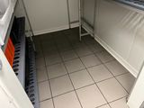 a small kitchen with tile flooring and white walls