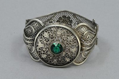 un gros plan d'une bague en argent sertie d'une pierre verte