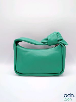 Le petit sac à main vert est orné d'un nœud sur le devant.