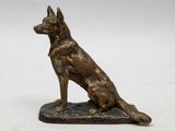 a statue of a dog sitting on top of a wooden base