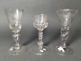 three glass goblets sitting next to each other on a table