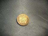 a close up of a gold coin on a black surface