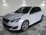 la voiture blanche est garée sur un sol en damier dans le garage