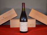 a bottle of wine sitting on a table next to two wooden boxes