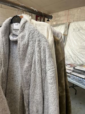 many coats hanging on a rack in a room