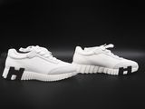 a pair of white sneakers with black soles on a black background