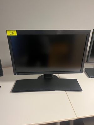 un bureau d'ordinateur sur lequel sont posés un écran et des haut-parleurs