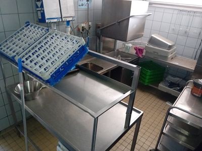 a kitchen with a metal cart with dishes on it