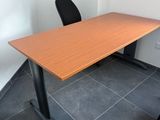 une photo représentant une table en bois avec deux chaises noires dans une pièce