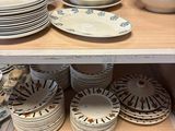 de nombreuses assiettes et bols sur une étagère dans un magasin