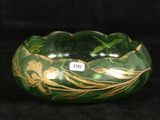 a green bowl with gold designs on it on a black background