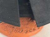 a close up of a black and orange object on a white surface