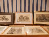 four framed pictures on a table in front of a striped wall